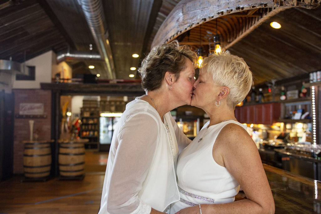 Detroit lesbian couple kissing leaning against the bar