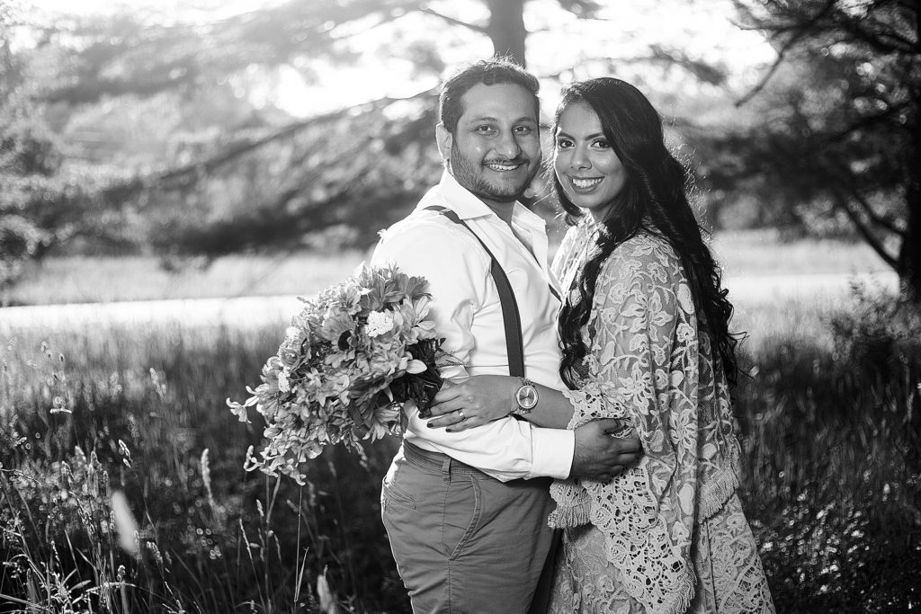 Black and white image of boho wedding couple holding each other