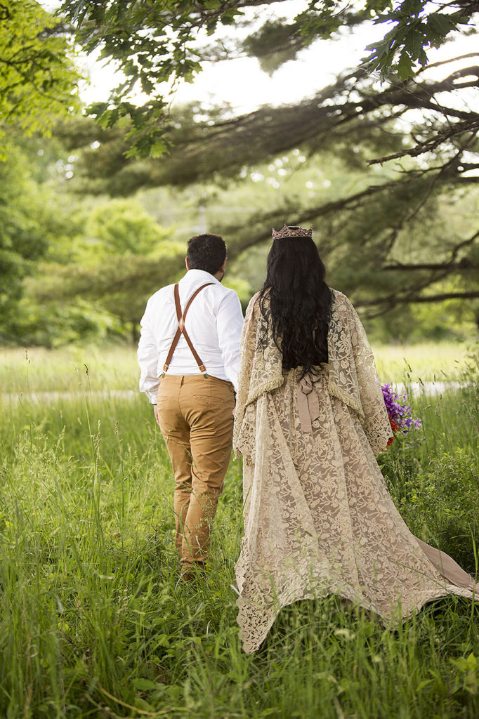 Boho bride and groom walk hand in hand