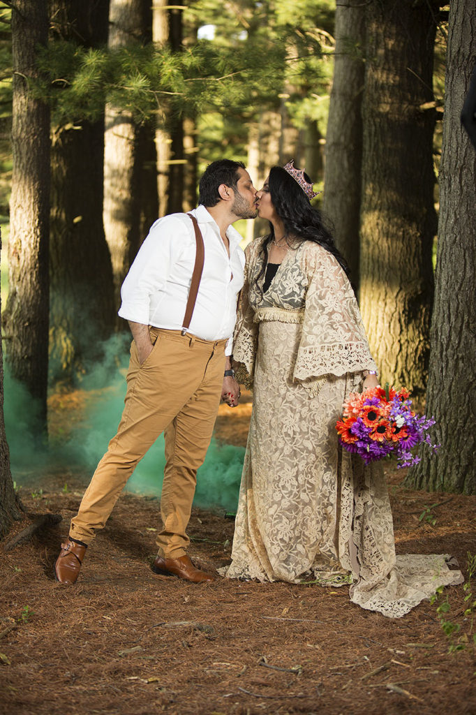 Boho couple kisses in front of green smoke bomb