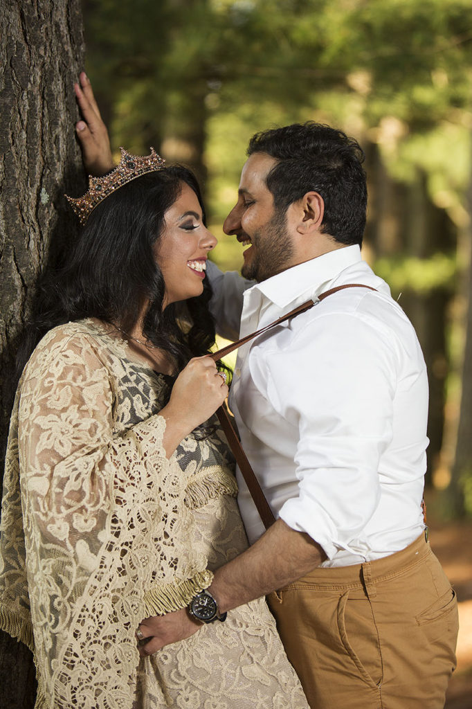 Boho bride pulls in her groom with his suspenders