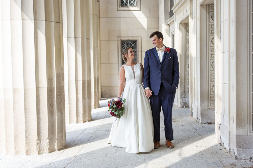 Couple walks in front of the old post office in Jackson Michigan wedding