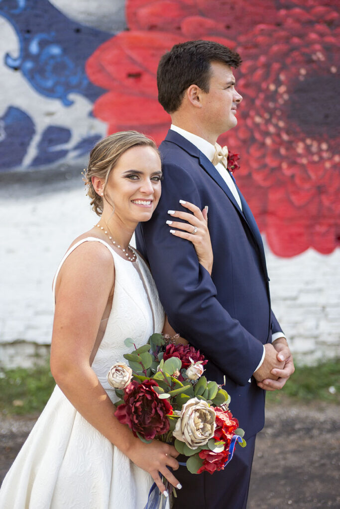 Couple poses in front of Bright Walls mural in Jackson Michigan