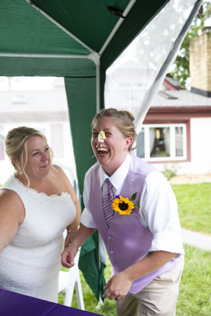 Cake smeared on bride's face during Westland backyard wedding cake cutting