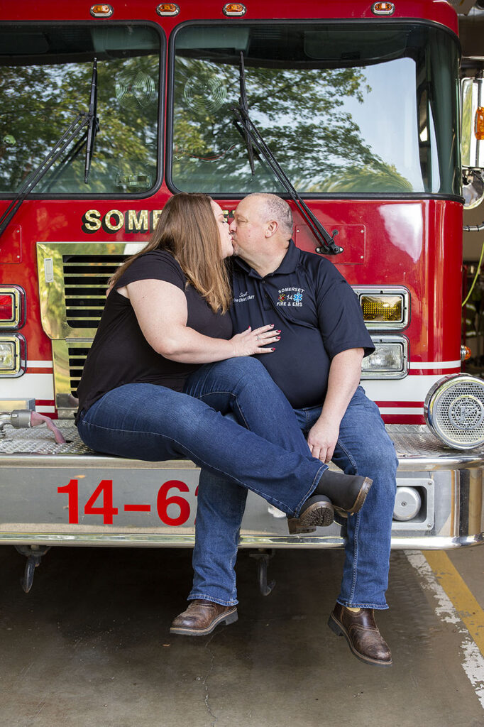 Fire department engagement session couple sitting on fire engine