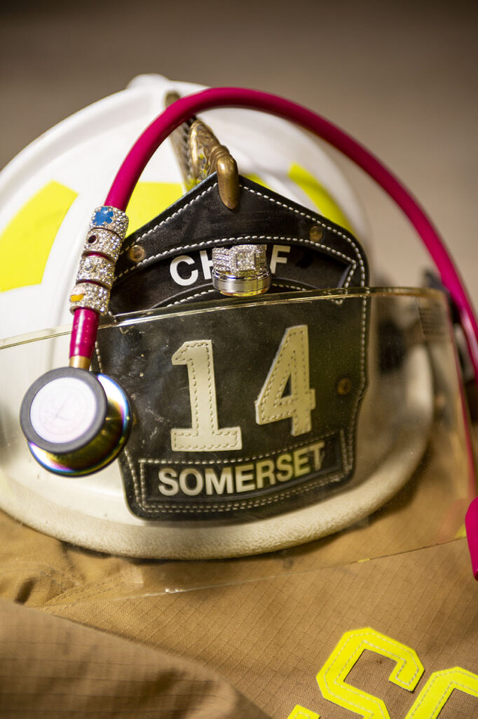 Engagement rings with helmet and stethoscope during fire department engagement session in Jackson, MI