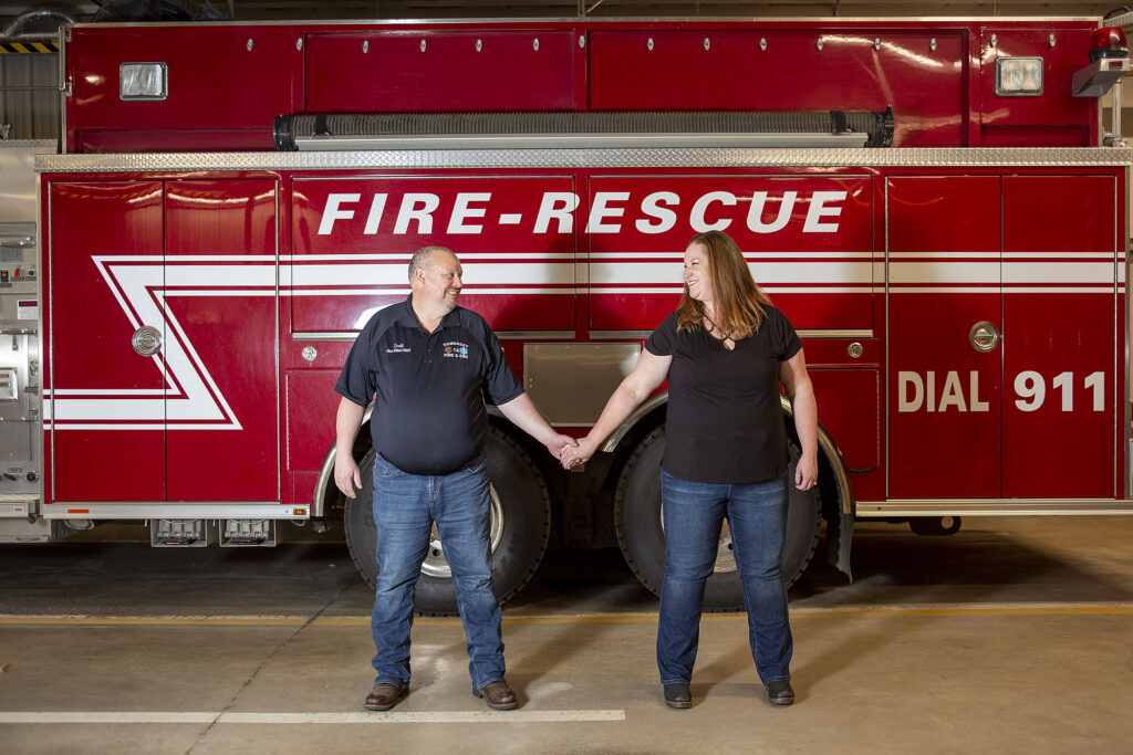 Fire department engagement session couple holds hands