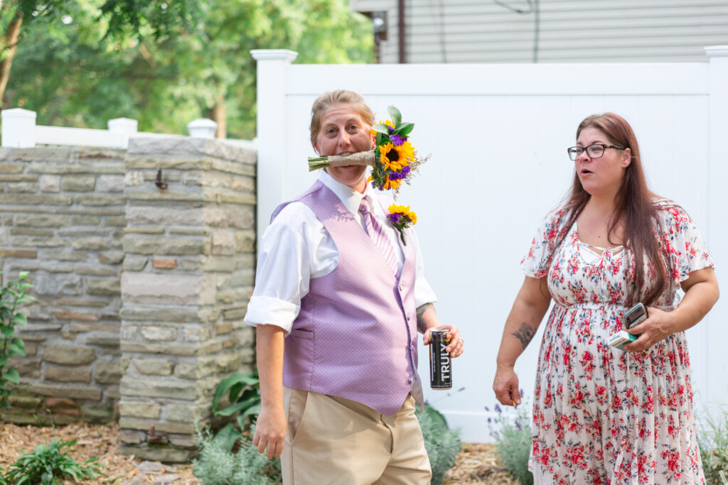 Bride holding sunflower bouquet in her mouth at her Westland wedding