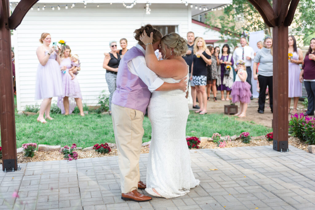 Lesbian wedding couple touch foreheads together during their first dance Westland wedding