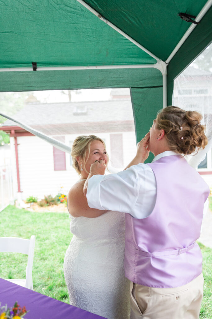 Westland wedding brides feeding each other cake at their LGBT wedding