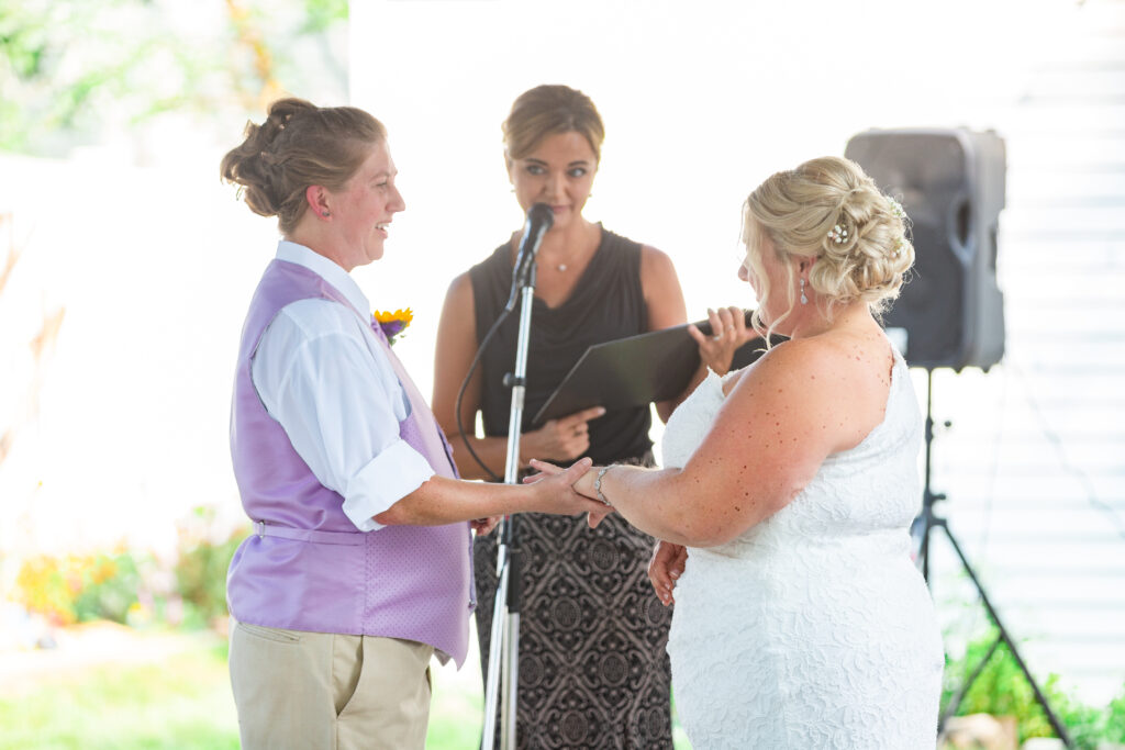 Same sex wedding couple exchanging vows at their backyard Westland wedding