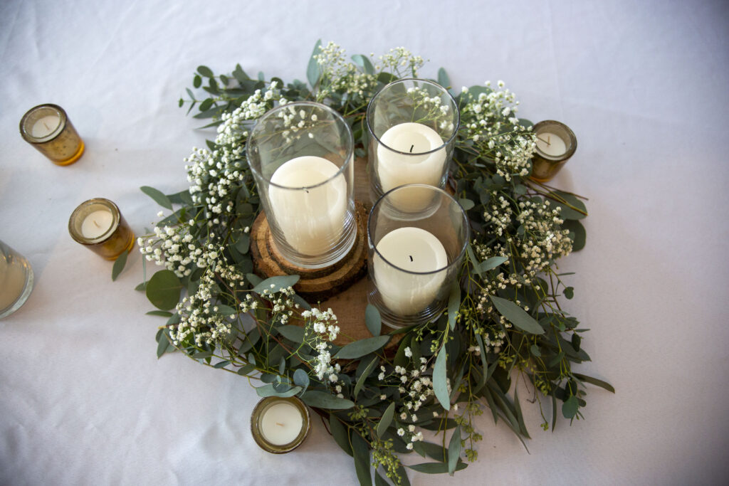 Greenery and white pillar candles at Michigan AirBNB wedding