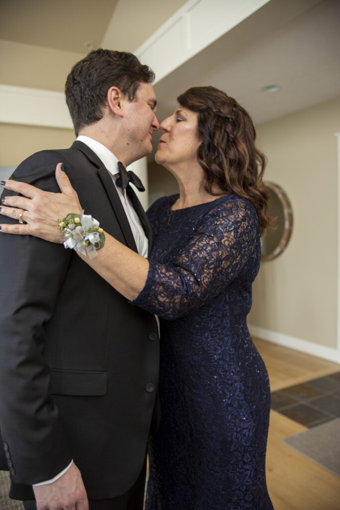 Groom's mom gives him a kiss before his Michigan AirBNB wedding starts