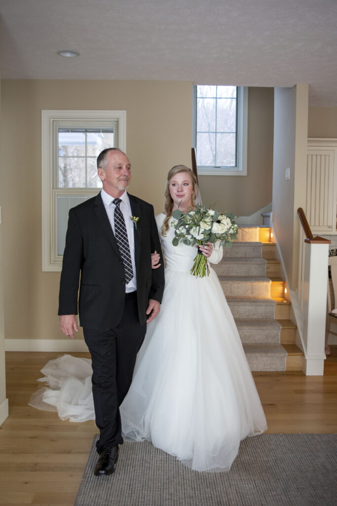 Bride and father round the corner to walk down the aisle at her Michigan AirBNB wedding