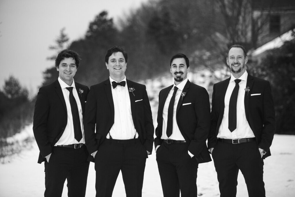 Groomsmen smiling in black and white at Lake Michigan AirBNB wedding