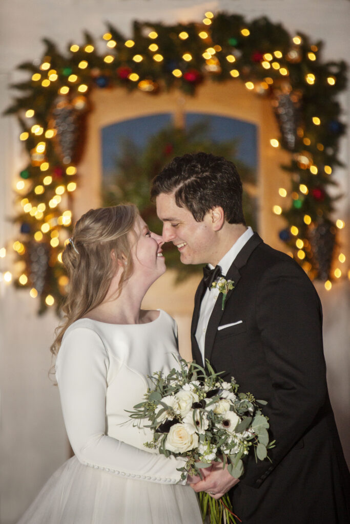 Couple getting ready to kiss in front of holiday lights at luxury AirBNB wedding Holland, MI