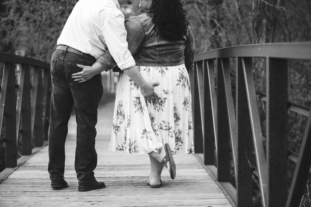 Black and white of Kensington Metropark engagement couple grabbing each others butts