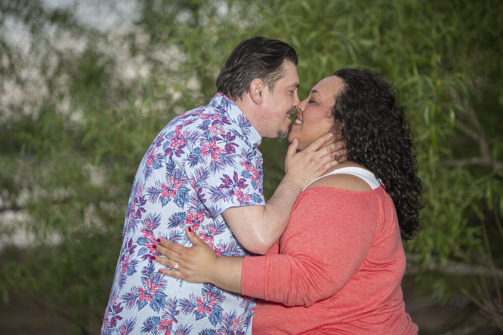 Couple kissing on beach during Kensington Metropark engagement session