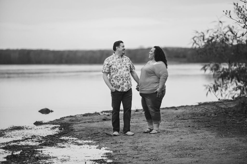 Mel and Sally laughing together on the beach during Kensington Metropark engagement session