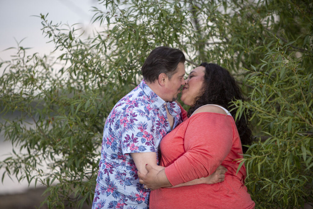 Sally and Mel kissing amongst the branches of a weeping willow Kensington Metropark engagement photos