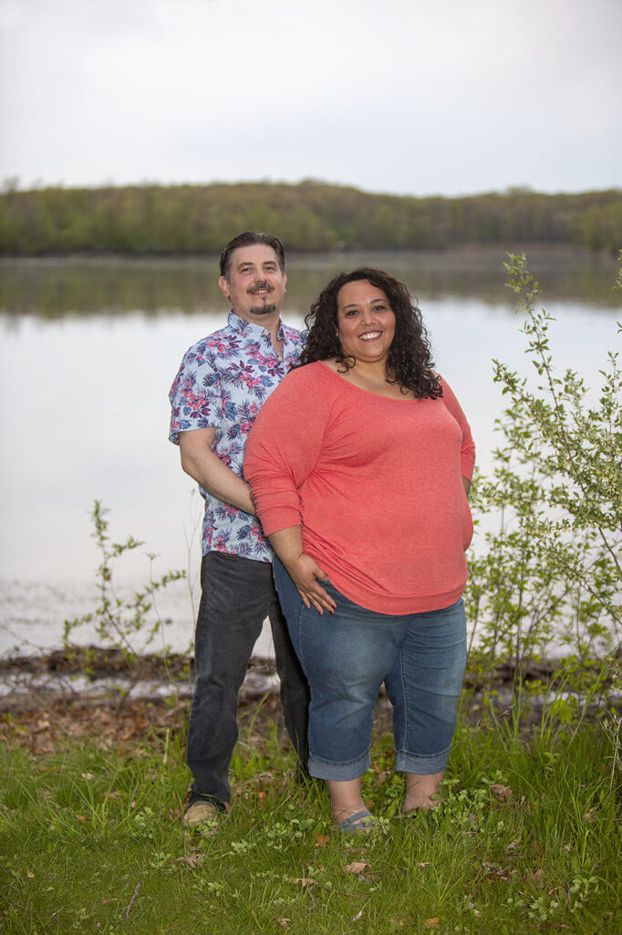 Couple standing on the shore of the lake during their Kensington Metropark engagement session