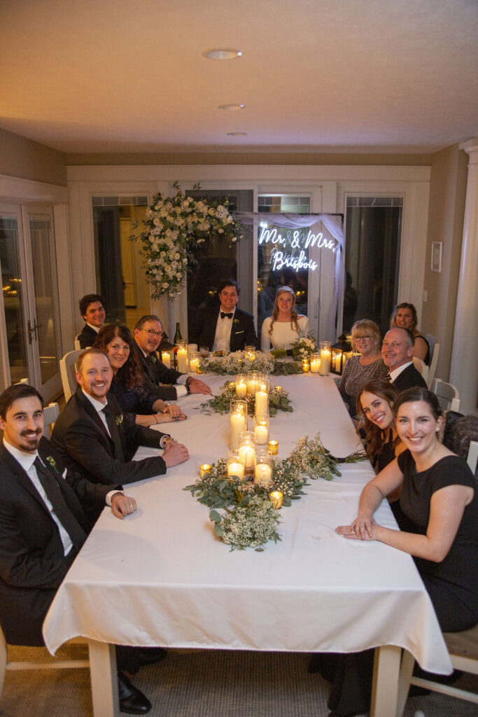 All of the wedding guests gathered around the dinner table of luxury Michigan AirBNB wedding