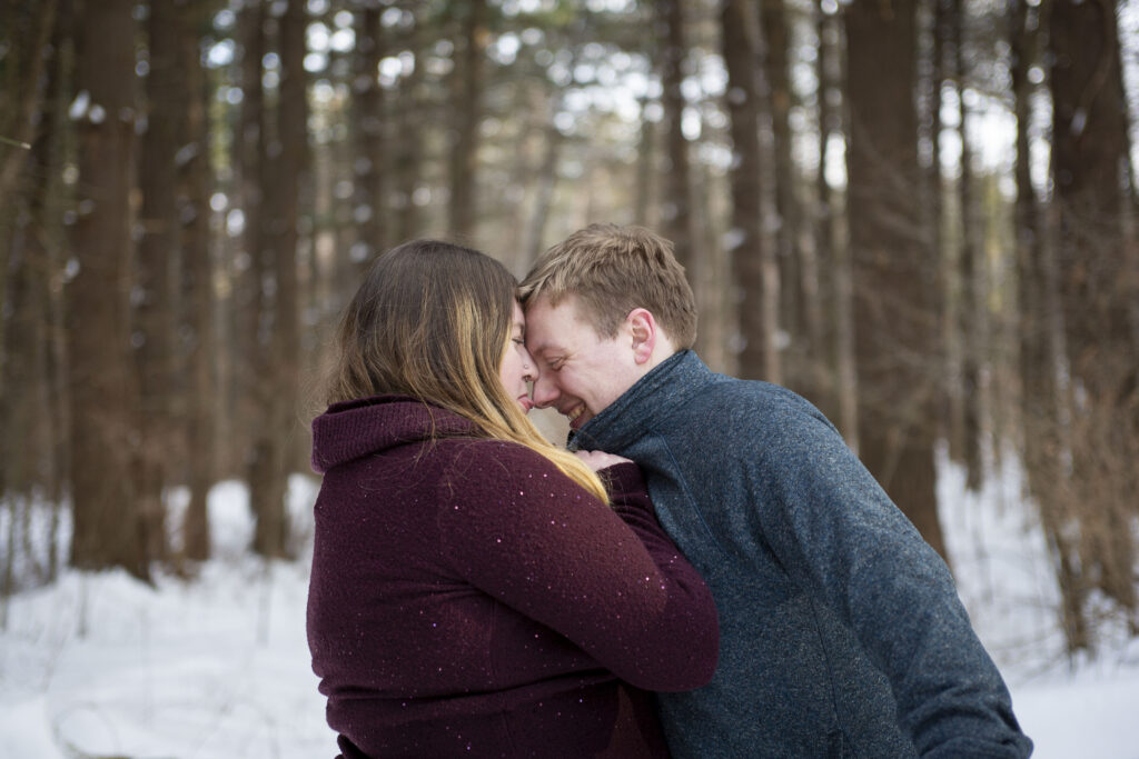 Sara licks the tip of Jerry's nose during Michigan winter couple's photos