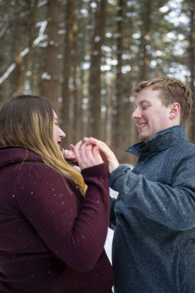 Couple smiling at each other during Michigan winter couple's photos