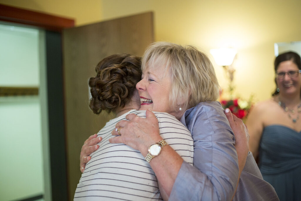 Mother of the groom hugging bride before her Plymouth wedding