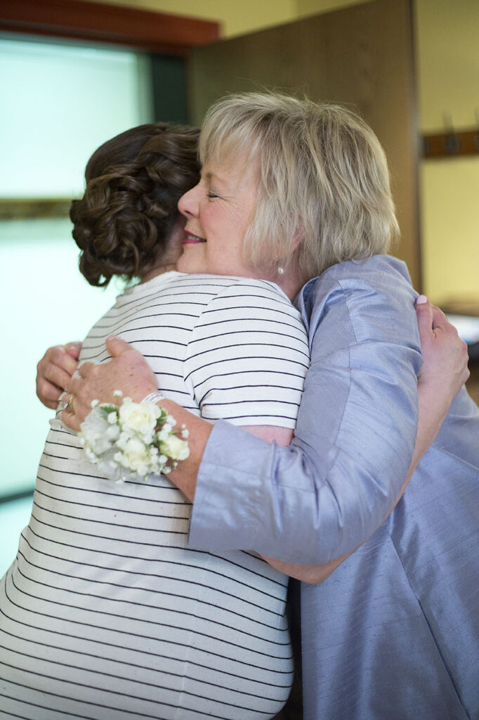 Bride hugging mother before her Plymouth wedding