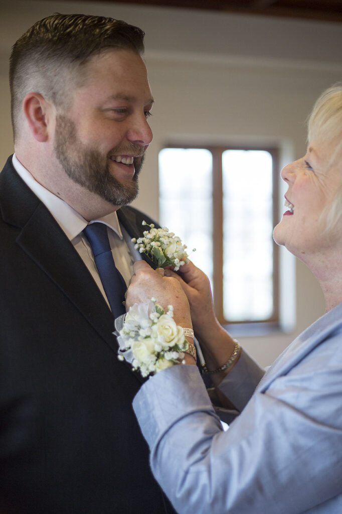 Mother and son smiling at each other before his Plymouth wedding