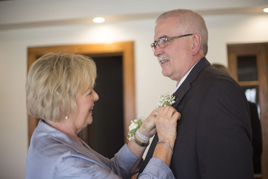 Mom pinning on boutonniere before Plymouth wedding