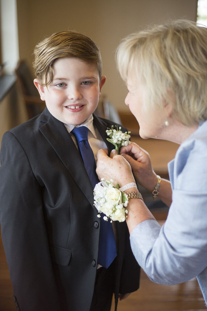 Ring bearer getting his boutonniere pinned on before the Plymouth wedding