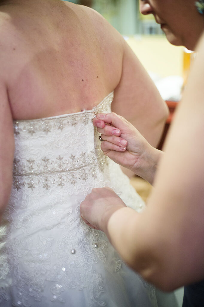 Zipping up Danielle's wedding dress before her Plymouth wedding