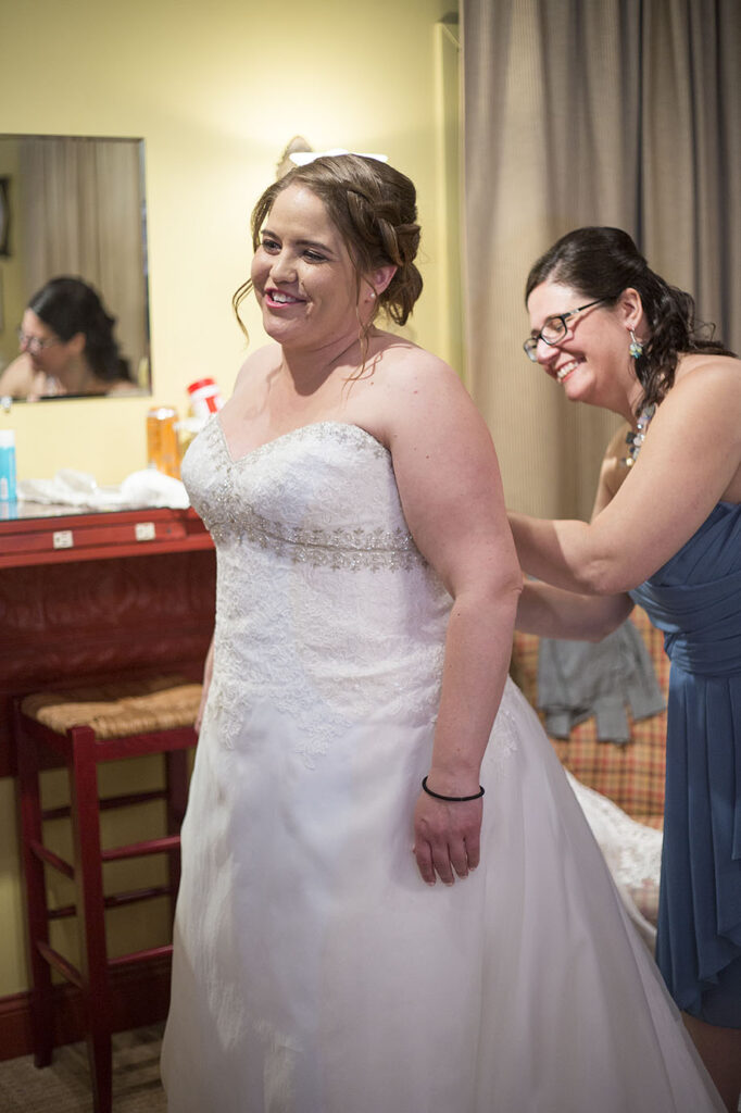 Bride putting her wedding dress on before her Plymouth wedding