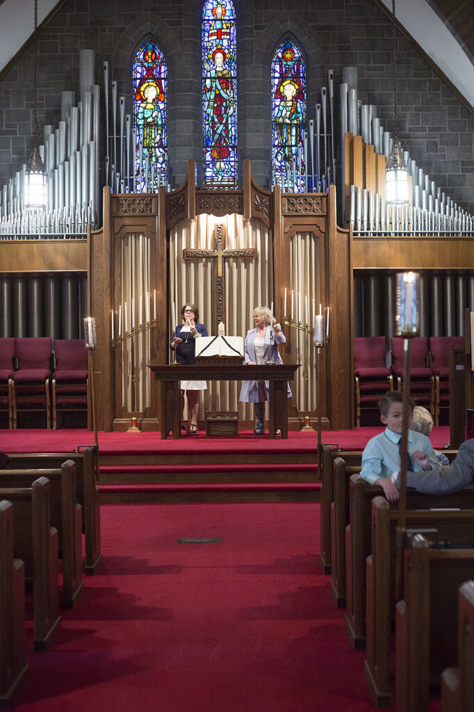 Mother's getting ready to light the candles at altar during Plymouth wedding