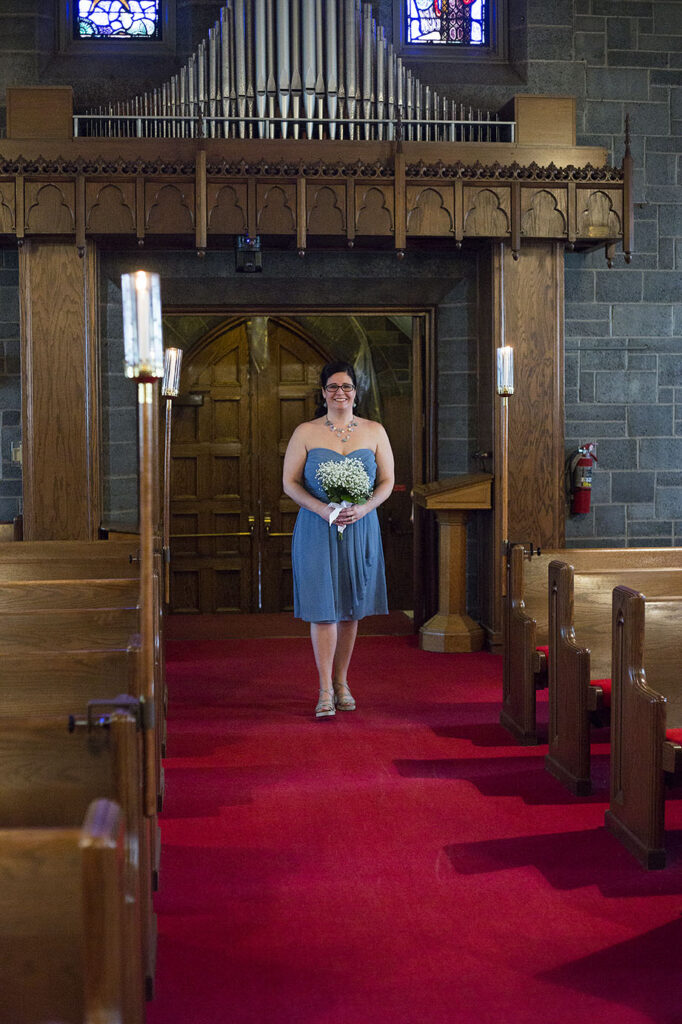 Bridesmaid walking down the aisle at Plymouth wedding