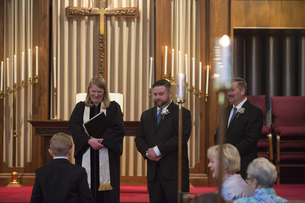 Groom looking at ring bearer as he walked down the aisle at Plymouth wedding