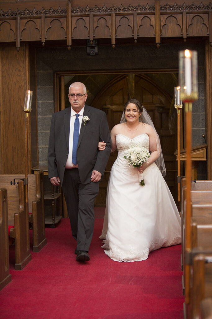 Bride walking down the aisle with her father doing Plymouth wedding