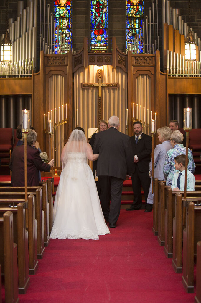 Bride walking down the aisle with her father at Plymouth wedding