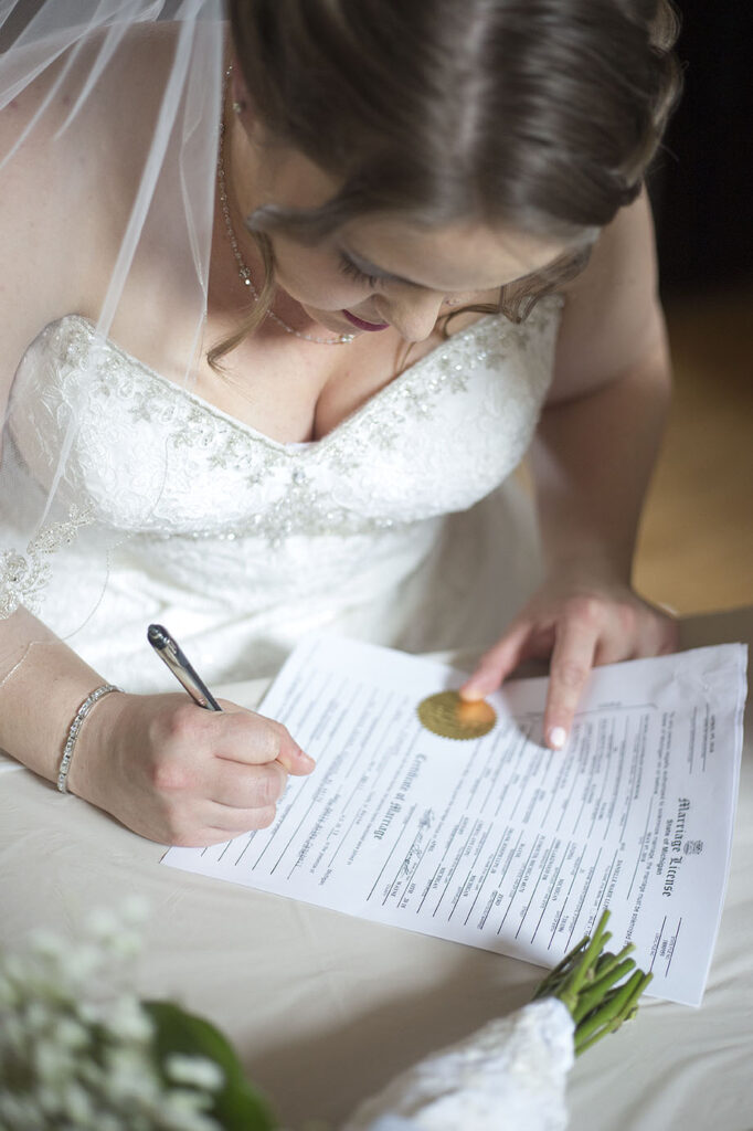 Bride signing marriage license at Plymouth wedding