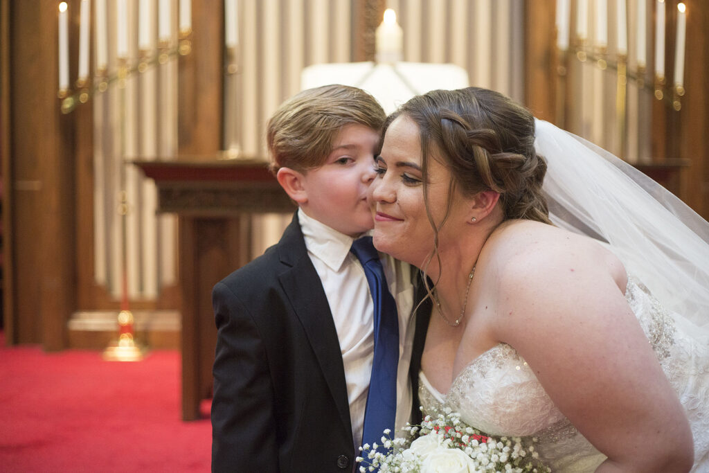 Bride's son kissing her cheek at Plymouth wedding