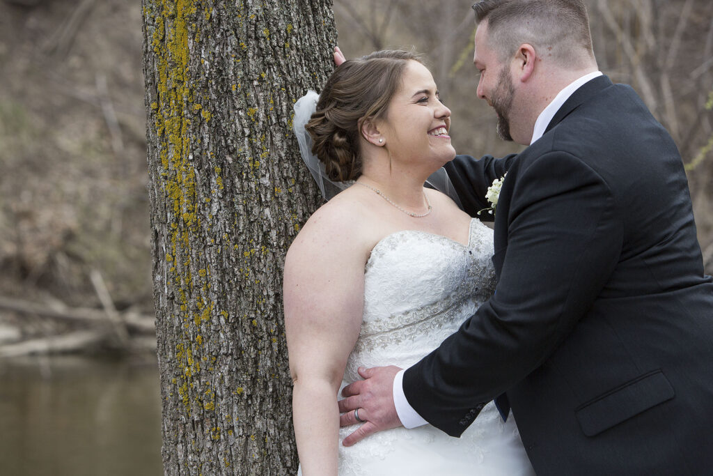 Michigan couple leaning up against a tree after Plymouth wedding