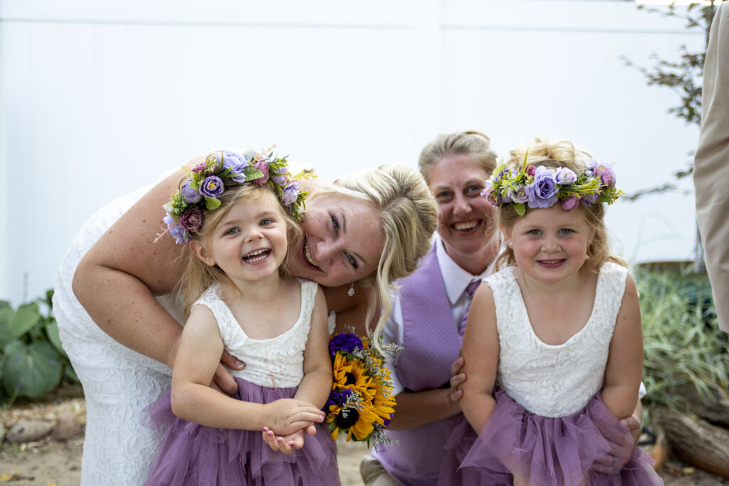 Same sex couple poses with their flower girls at their Westland wedding