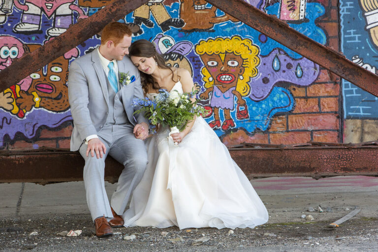 Jackson counrty club wedding couple sitting underneath a train bridge with graffiti in the background