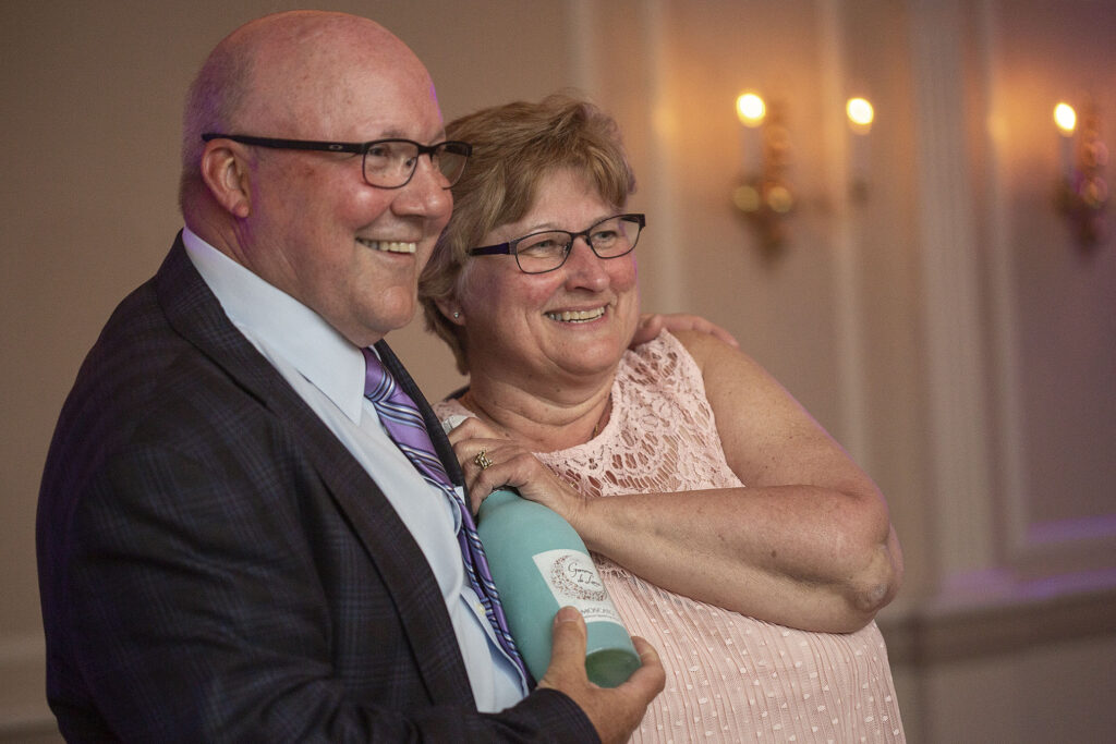 Parents smile while watching their daughter dance at her wedding