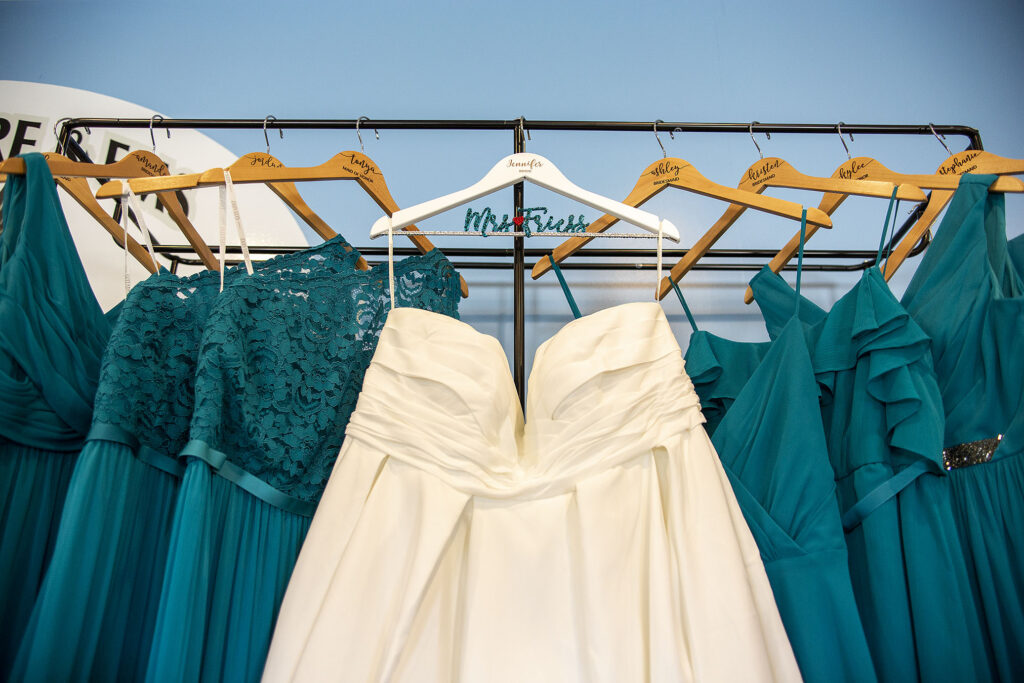 Addison wedding dress hanging with bridesmaids dresses