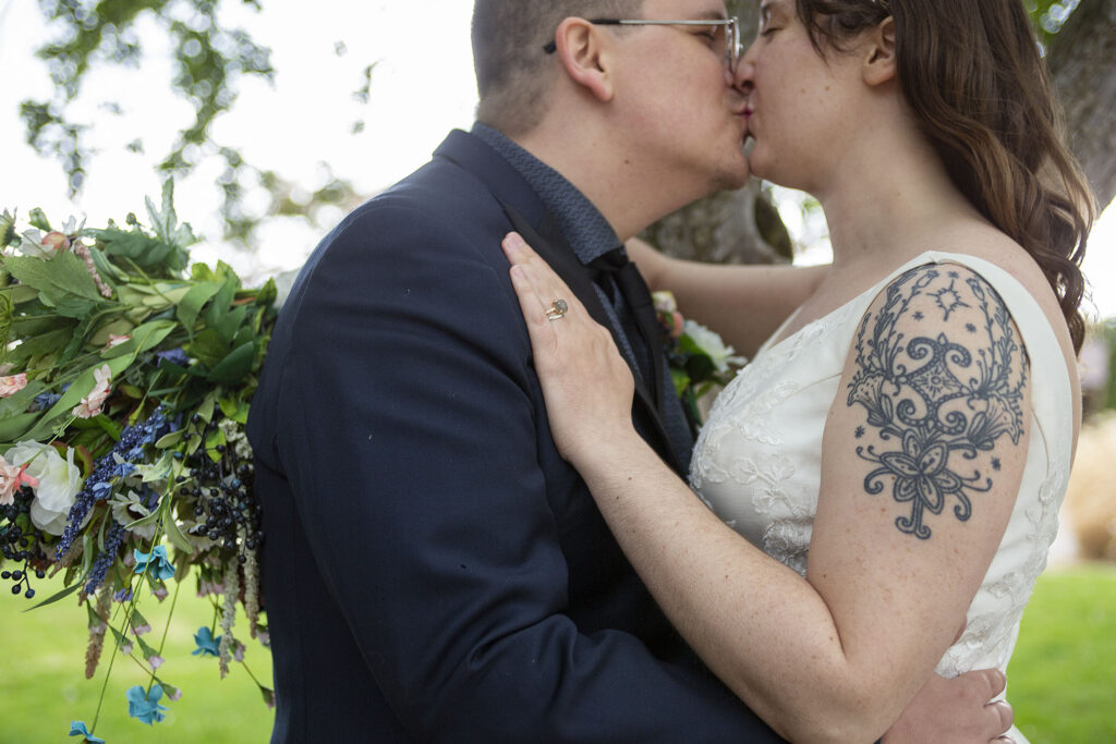 Micro wedding tattooed couple kissing