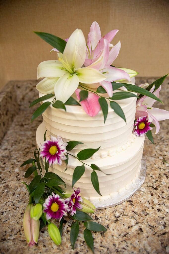 Belleville wedding cake decorated with lillies and other florals.