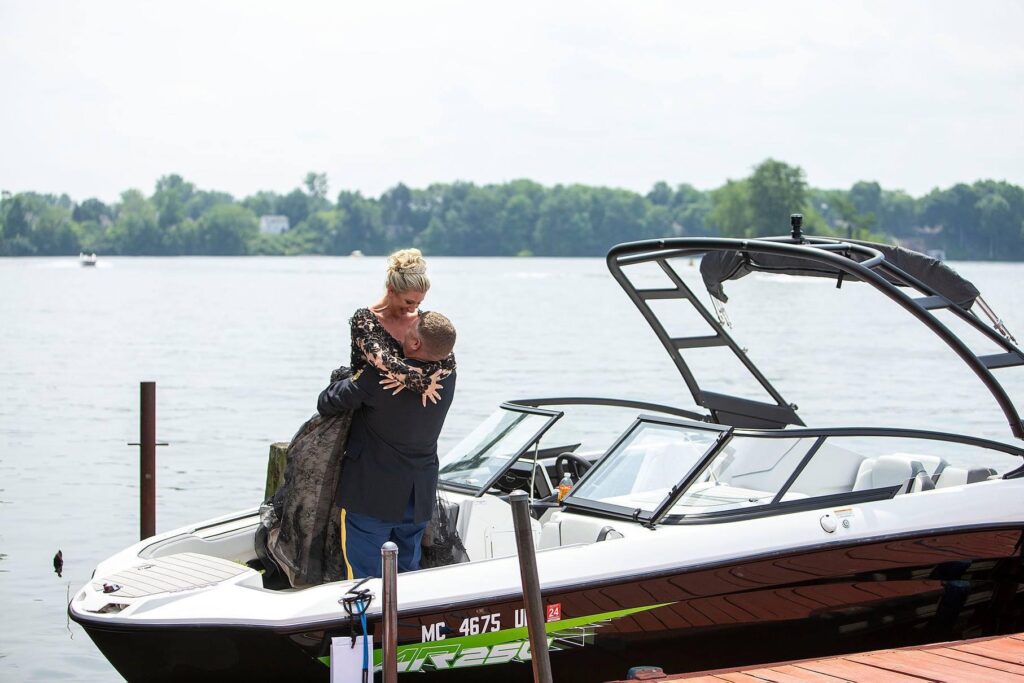 Black wedding dress bride being lifted into the air by new husband on Belleville Lake in Belleville Michigan.